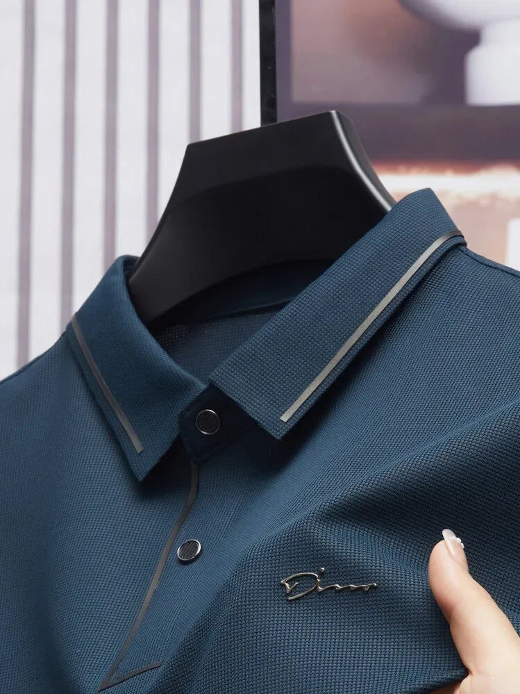 Camisa Polo Fontaine da Oron Store em fundo branco. Modelo masculino de verão 2025 com gola clássica e mangas curtas, disponível nas cores bege, verde, vermelho, azul e preto. Confeccionada em tecido leve de algodão e poliéster, ideal para adultos que buscam estilo e conforto em dias quentes. Roupa casual moderna com caimento ajustado, disponível nos tamanhos PP ao G1.