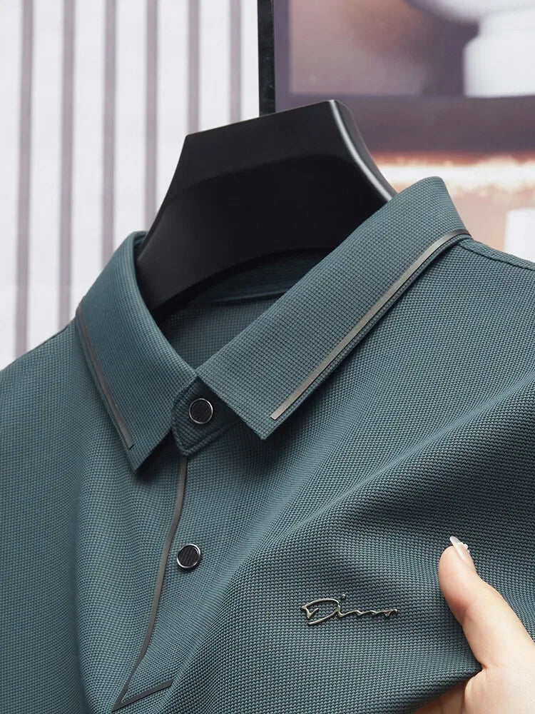 Camisa Polo Fontaine da Oron Store em fundo branco. Modelo masculino de verão 2025 com gola clássica e mangas curtas, disponível nas cores bege, verde, vermelho, azul e preto. Confeccionada em tecido leve de algodão e poliéster, ideal para adultos que buscam estilo e conforto em dias quentes. Roupa casual moderna com caimento ajustado, disponível nos tamanhos PP ao G1.