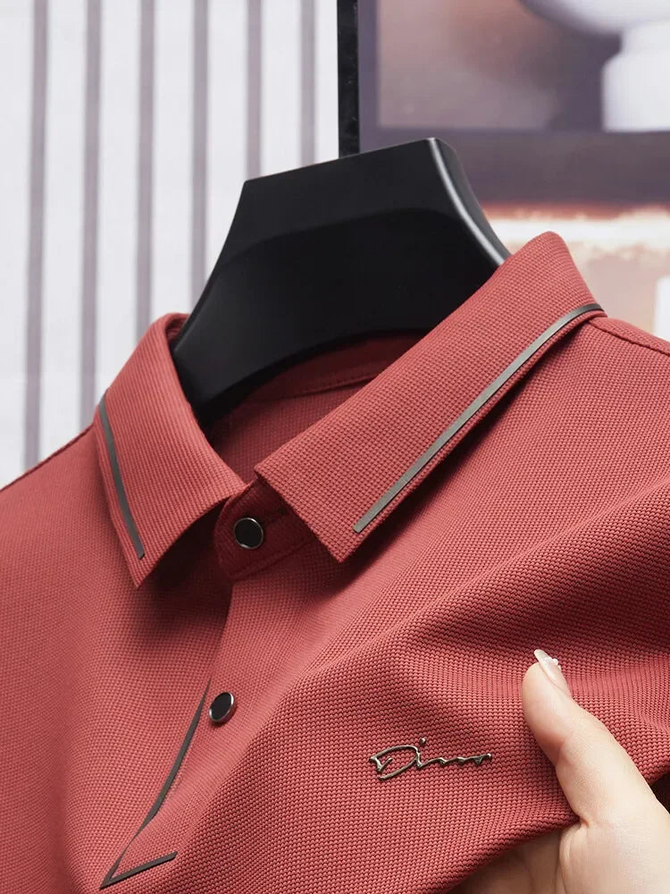 Camisa Polo Fontaine da Oron Store em fundo branco. Modelo masculino de verão 2025 com gola clássica e mangas curtas, disponível nas cores bege, verde, vermelho, azul e preto. Confeccionada em tecido leve de algodão e poliéster, ideal para adultos que buscam estilo e conforto em dias quentes. Roupa casual moderna com caimento ajustado, disponível nos tamanhos PP ao G1.