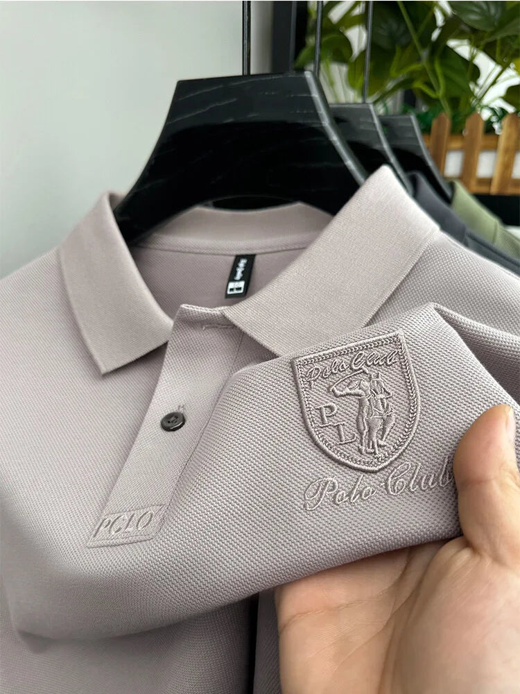 Camisa Polo Martin da Oron Store em fundo branco. Modelo masculino com corte clássico e mangas curtas, disponível nas cores cinza, bege, azul, preto, branco e verde. Confeccionada em tecido leve de algodão e poliéster, ideal para o verão 2025. Camisa polo casual e versátil, perfeita para adultos em busca de conforto e estilo. Disponível nos tamanhos P ao G2.