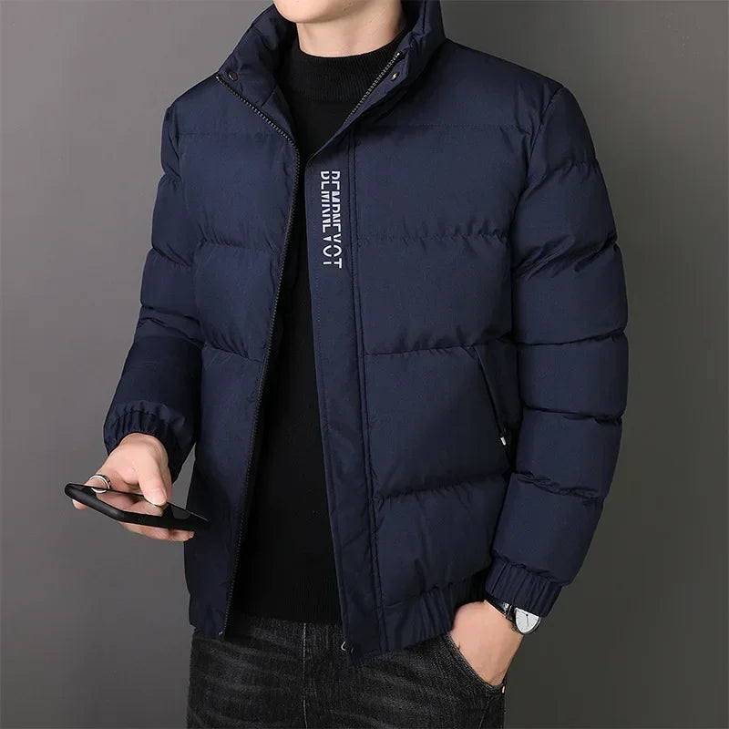 Jaqueta Masculina Nordic em fundo branco, modelo apresentado nas cores cinza, azul e preto. Jaqueta térmica com mangas longas, confeccionada em poliéster resistente e confortável, ideal para o inverno 2025. Design moderno com bolsos frontais e corte ajustado, disponível nos tamanhos P ao G1. Casaco masculino para adultos, estilo urbano e casual.