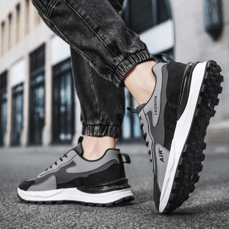 Tênis Casual Air Pro da Oron Store em fundo branco. Modelo unissex disponível nas cores branco e cinza, com cabedal em camurça e couro, e solado em borracha antiderrapante. Tênis casual com fechamento em cadarço, ideal para caminhadas, uso diário ou compor looks urbanos e confortáveis no verão 2025. Disponível nos tamanhos 37 ao 42.