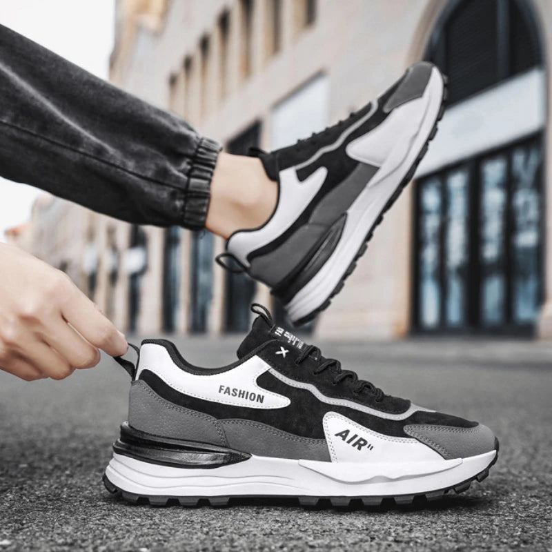 Tênis Casual Air Pro da Oron Store em fundo branco. Modelo unissex disponível nas cores branco e cinza, com cabedal em camurça e couro, e solado em borracha antiderrapante. Tênis casual com fechamento em cadarço, ideal para caminhadas, uso diário ou compor looks urbanos e confortáveis no verão 2025. Disponível nos tamanhos 37 ao 42.